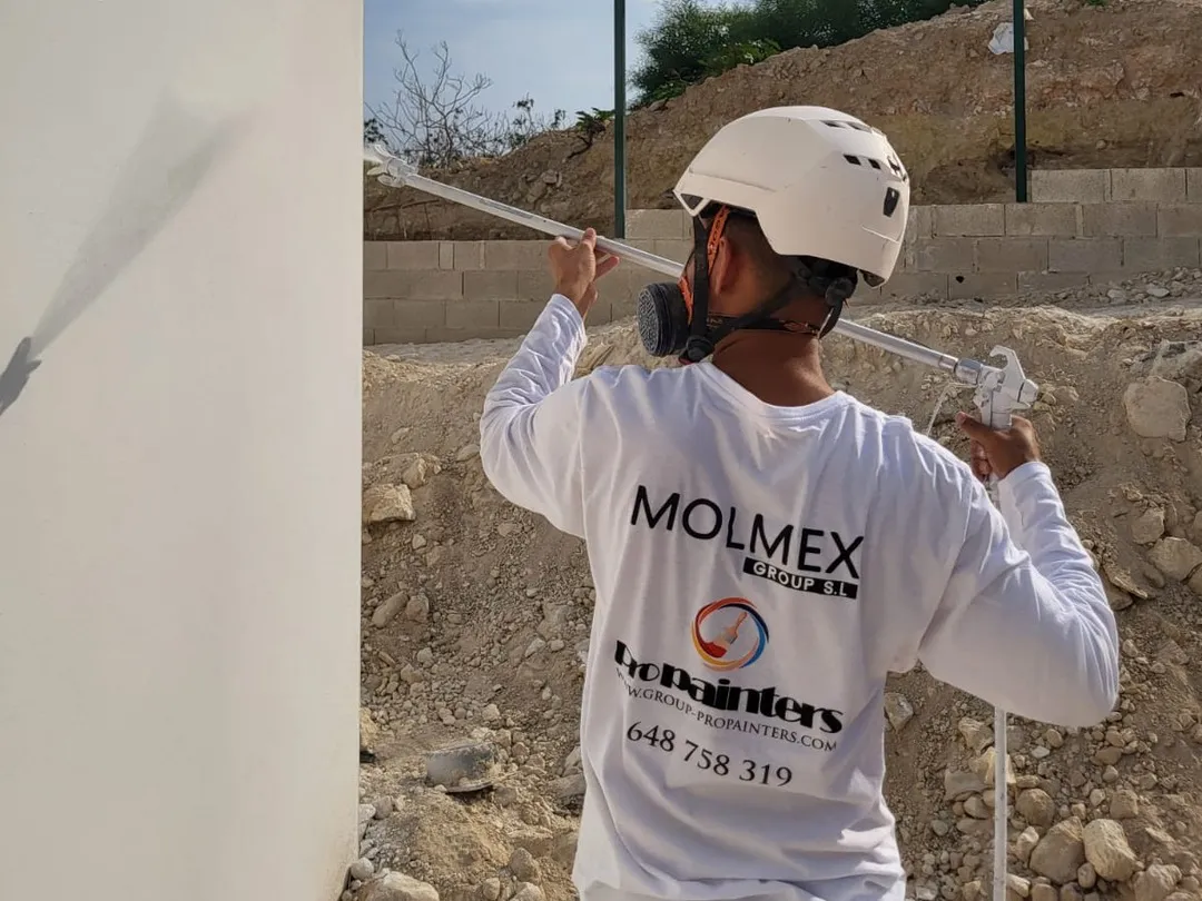 Pintor de Pro Services pintando una fachada con pistola airless